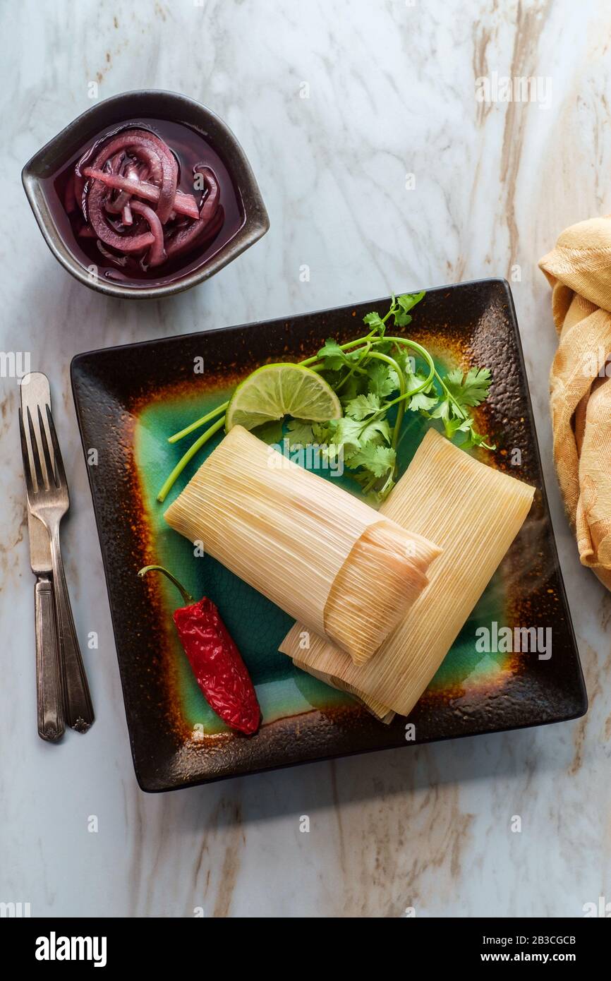 Mexican steamed chili and cheese masa tamales wrapped in corn husk