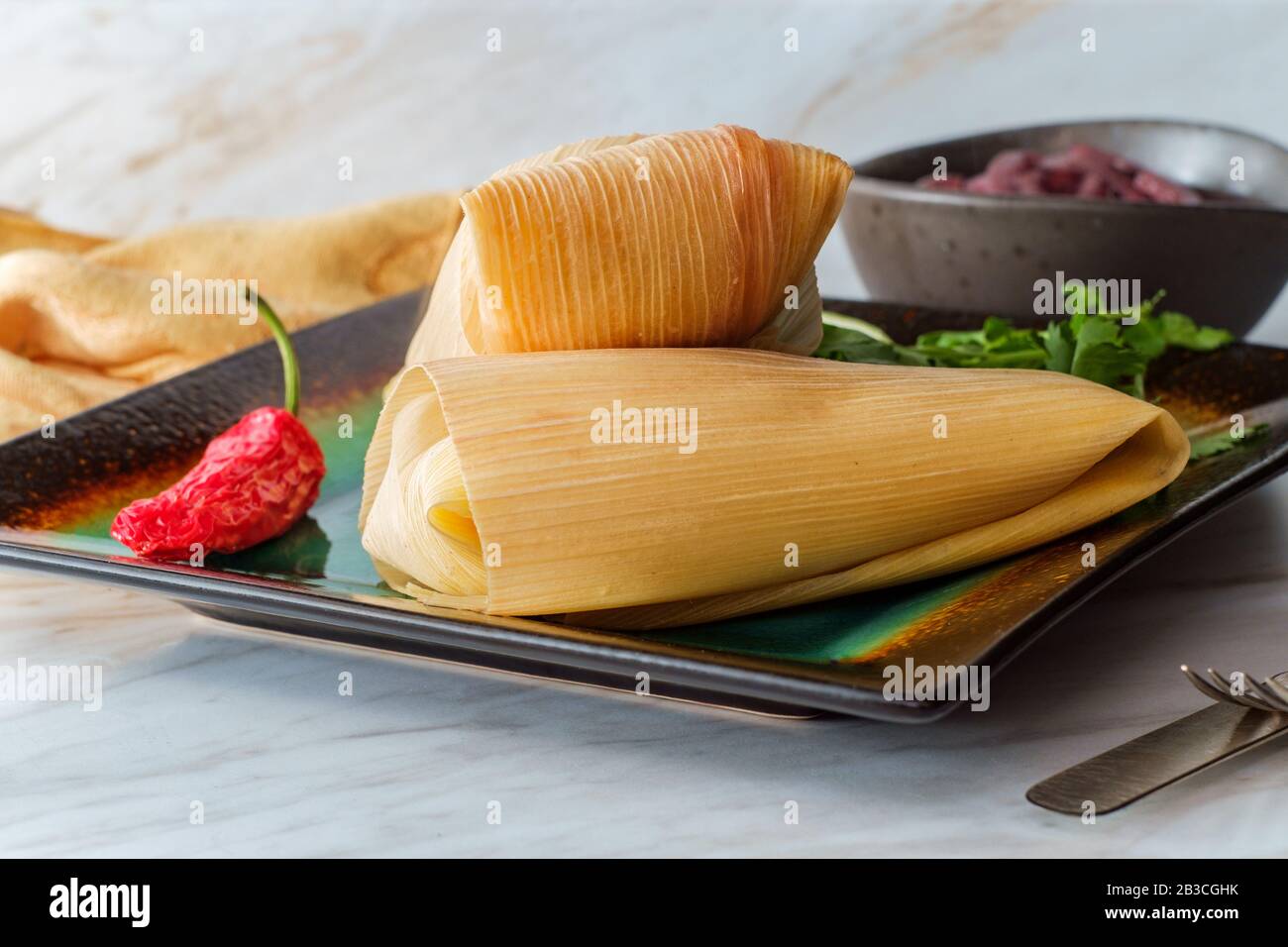 Mexican steamed chili and cheese masa tamales wrapped in corn husk