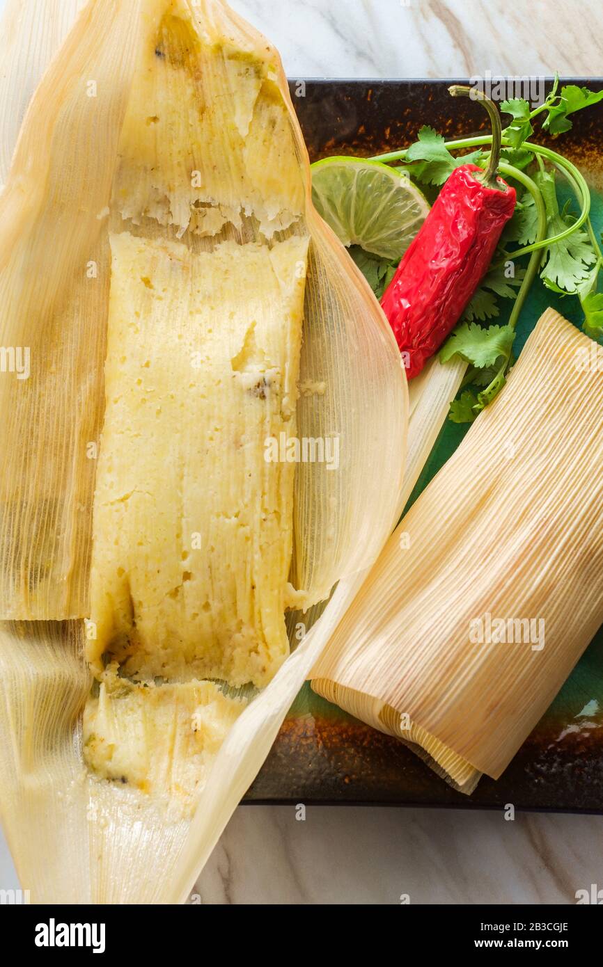 Mexican steamed chili and cheese masa tamales wrapped in corn husk