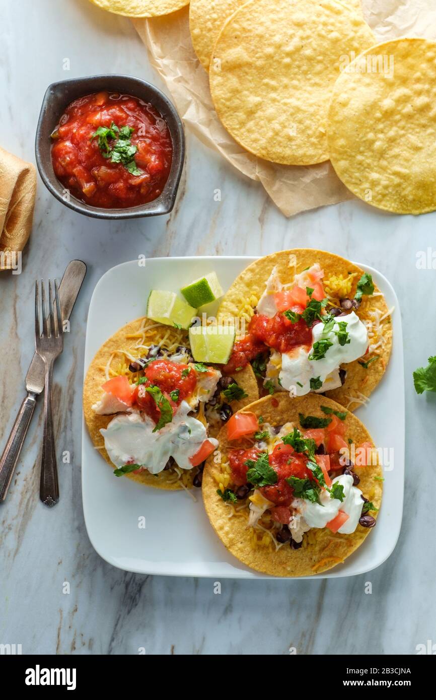 Mexican chicken tostada flat tacos with rice black beans salsa and sour