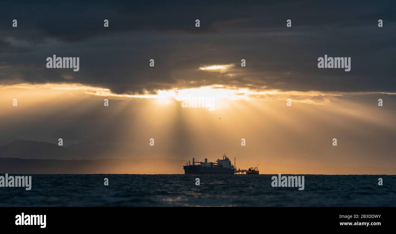Oil tanker ship in the ocean. Sunset sky. Early in the morning, the sunrise. South Africa. Mossel Bay Stock Photo