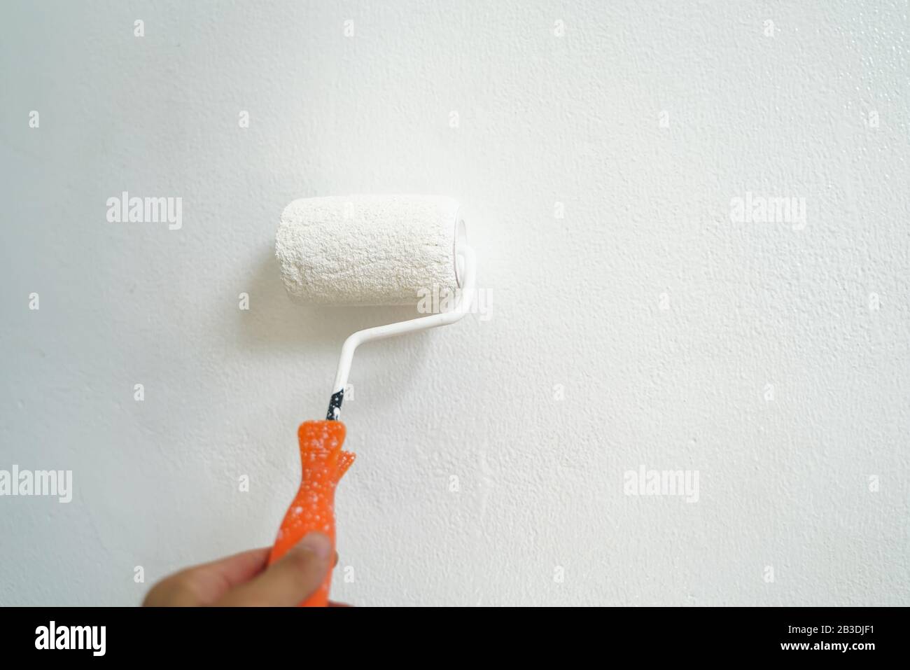 Home paint inside wall hand rolling close up DIY working Stock Photo