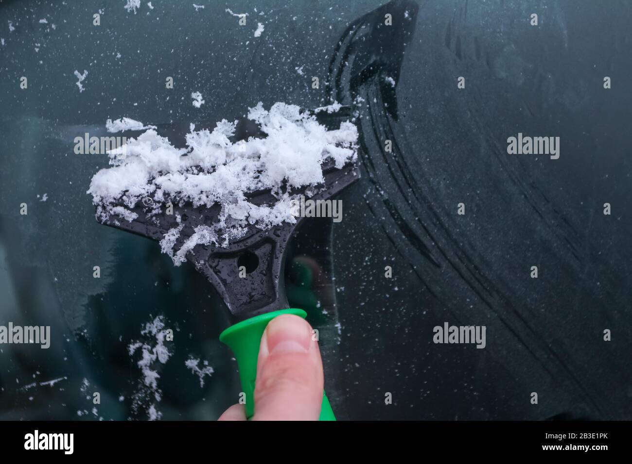 Cleaning a frozen car window with a metal scraper Stock Photo Alamy
