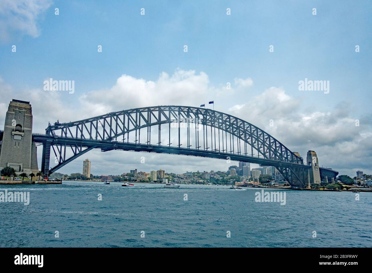 Sydney Harbour Bridge viewed from the water with people walking over the arch. Stock Photo