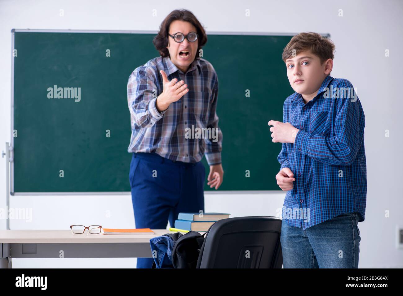 The funny male teacher and boy in the classroom Stock Photo - Alamy