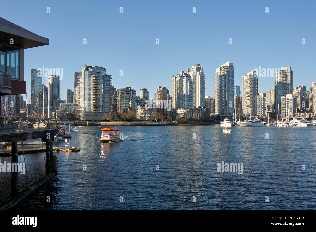 An Aquabus ferry crossing False Creek with with Yaletown skyline in back, Vancouver, BC, Canada Stock Photo