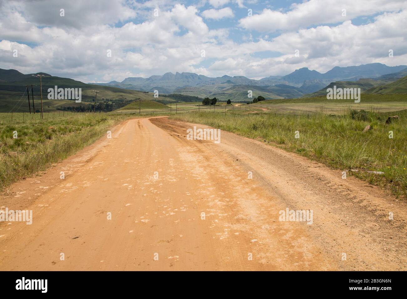 Winding dirt road leading into the Drakensberg mountains in South ...
