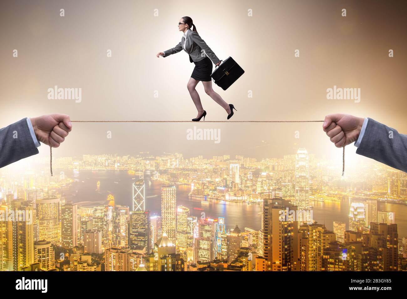 The businesswoman walking on tight rope Stock Photo - Alamy