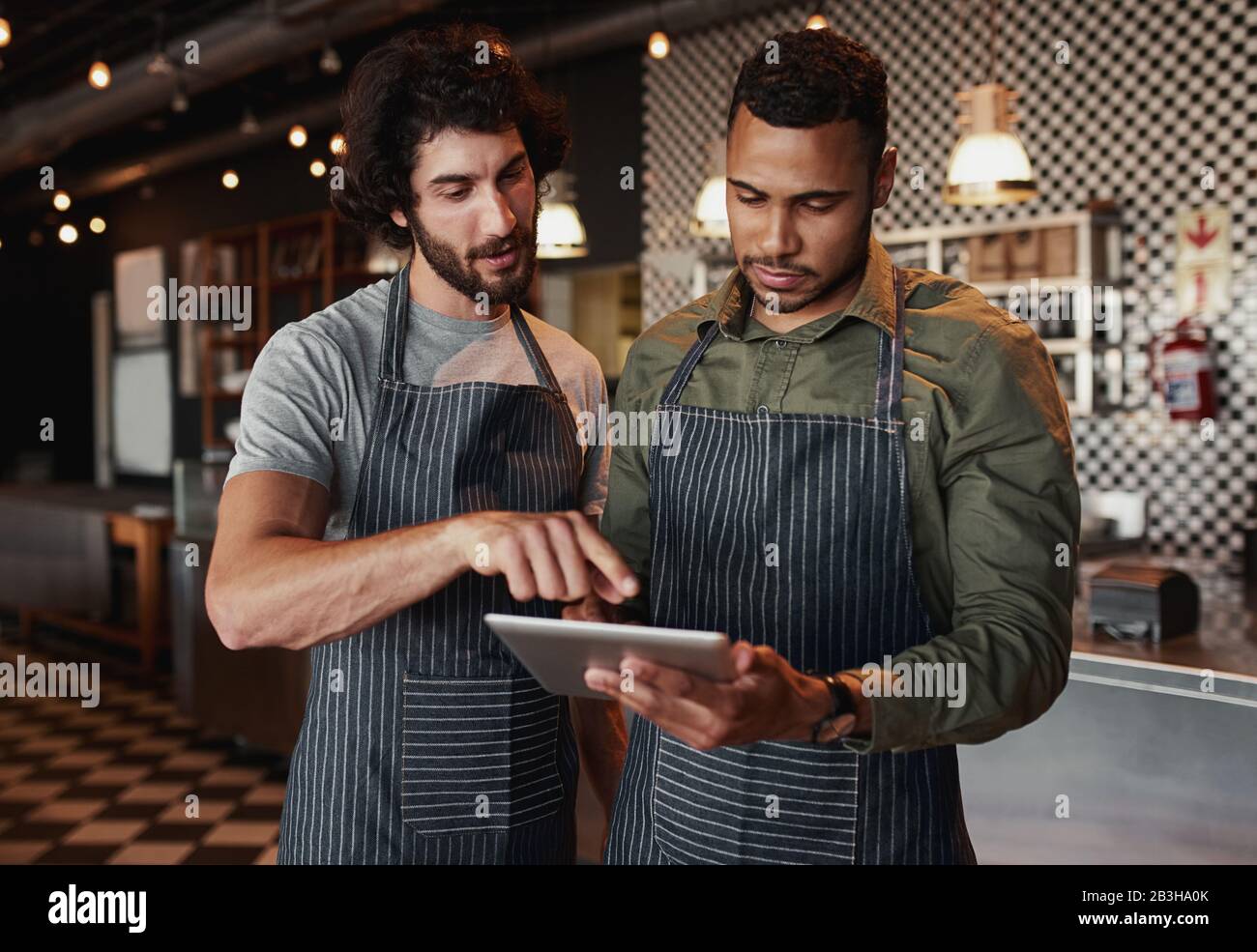 Cafe co-workers working together in cafe using digital tablet Stock Photo