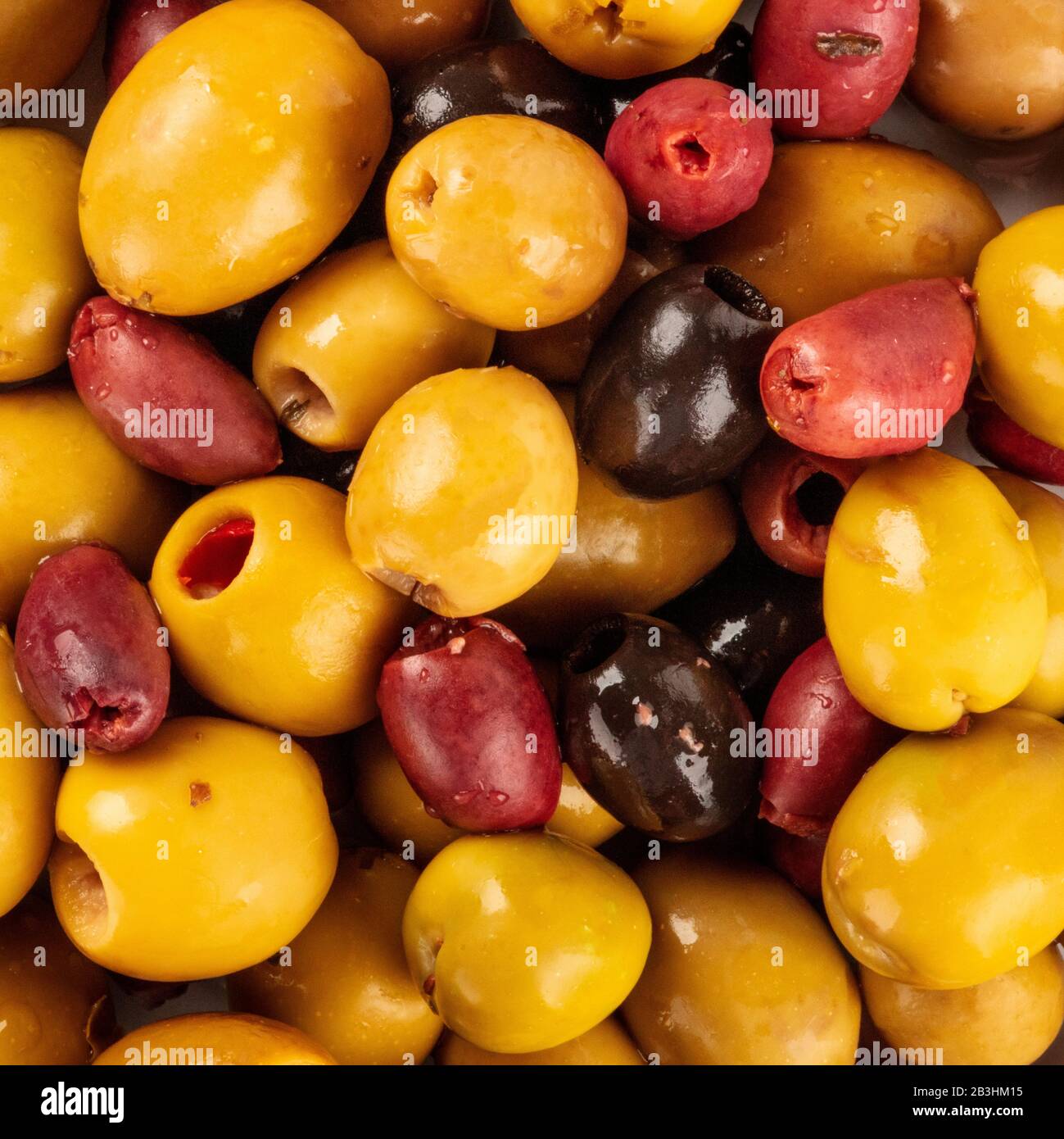 Olives square background texture. Black, green and red olives, an assortment, shot from the top Stock Photo