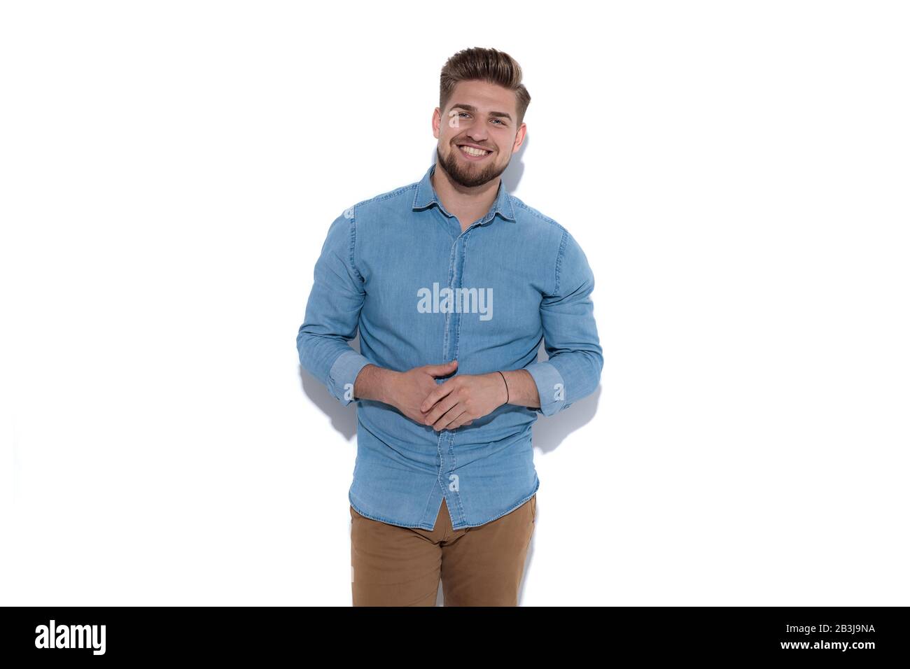 happy casual man hoding palms together and standing on white background Stock Photo