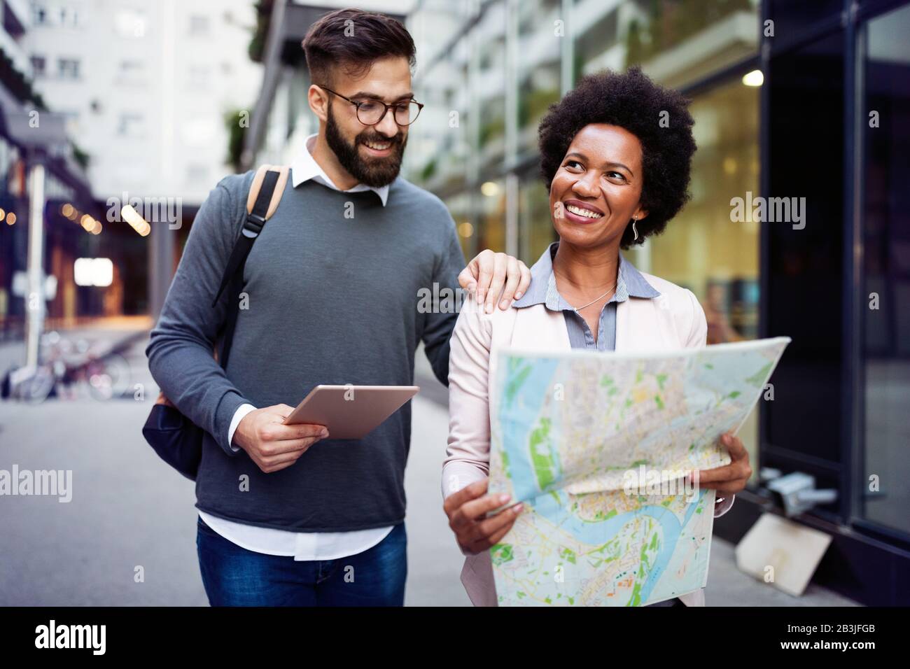 Lost happy couple in the city holding a map. Travel, tourism, people concept Stock Photo