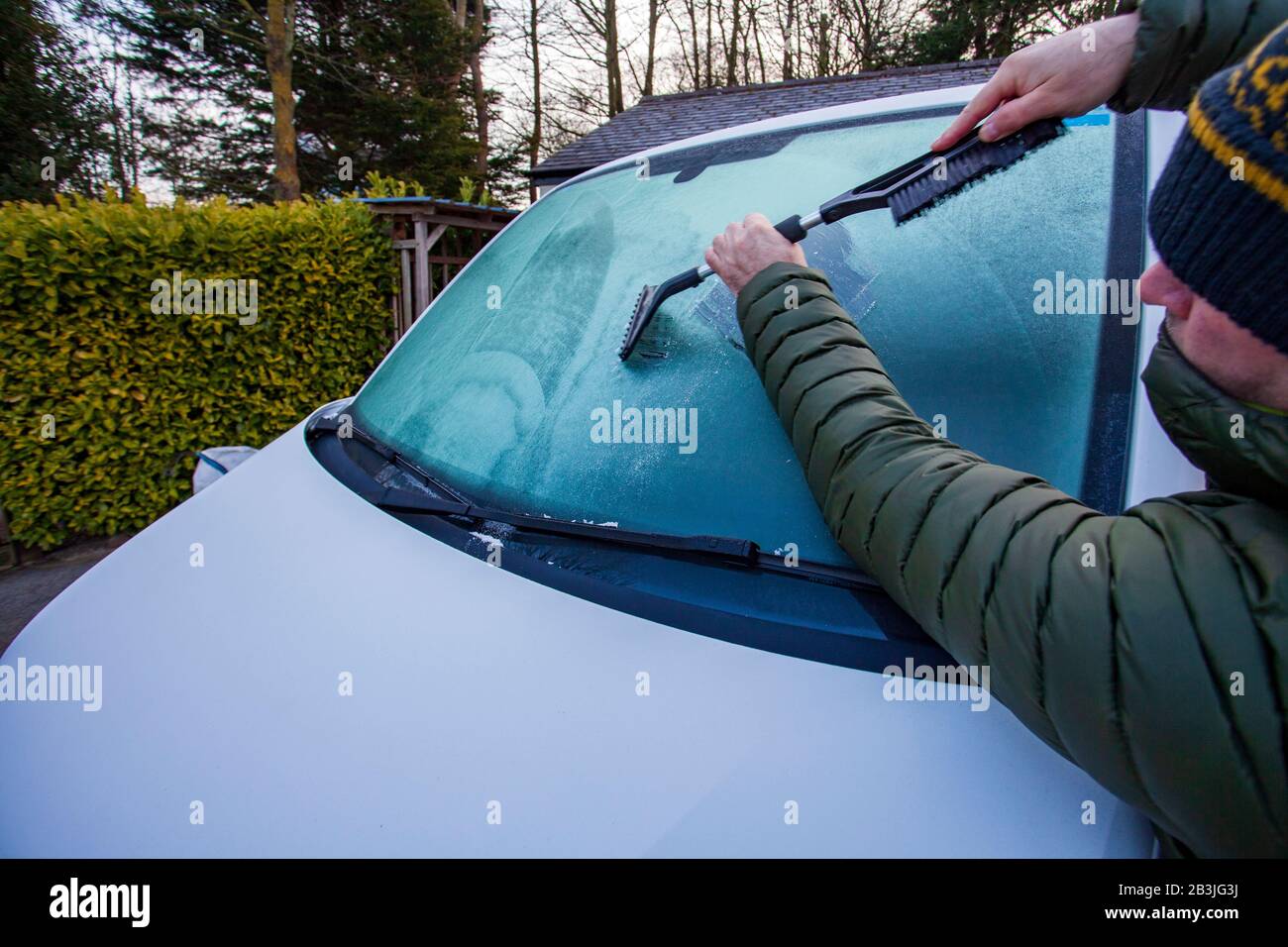Flintshire, North Wales, 5th March 2020. UK Weather:  A cold start to the day with temperatures falling overnight enough to leave a morning frost in the rural village of Lixwm in Flintshire. A comuter scraping ice off a windscreen after an overnight frost in the village of Lixwm, Flintshire © DGDImages/17�Թ�����LiveNews Stock Photo