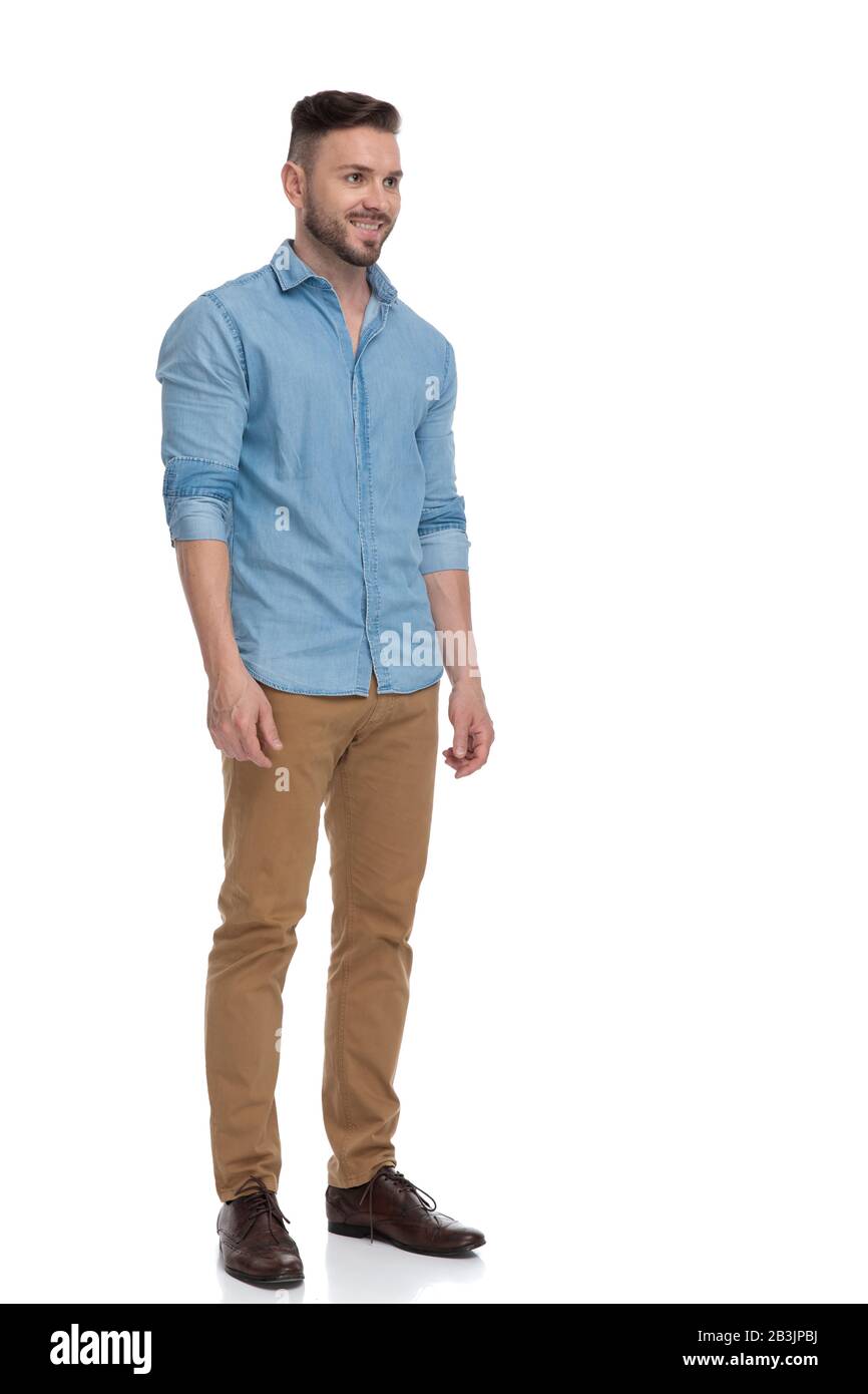 side view of a handsome casual man with blue shirt is standing and looking  ahead happy on white studio background Stock Photo - Alamy