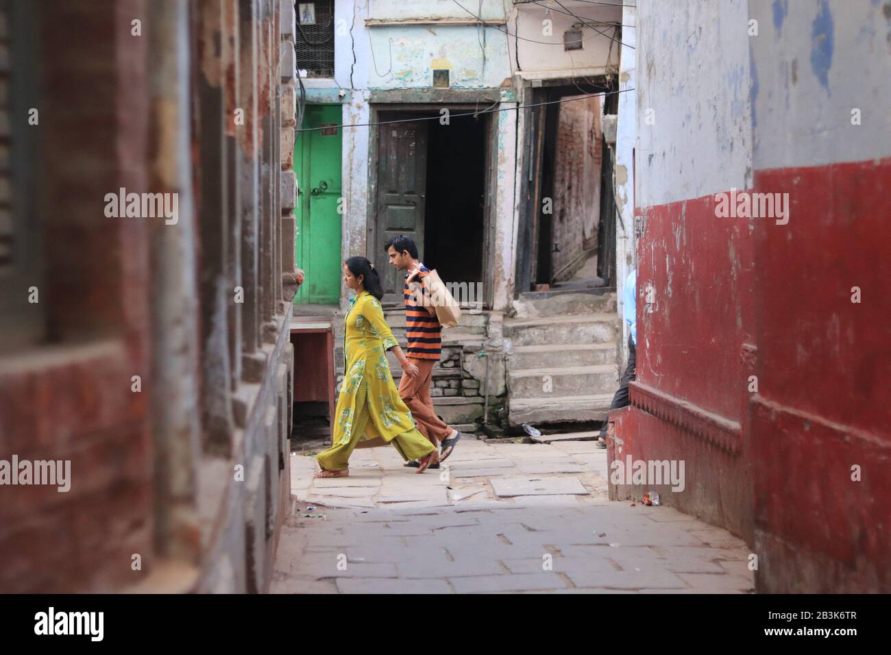 Indian couple walk on the small alley of Varanasi Stock Photo