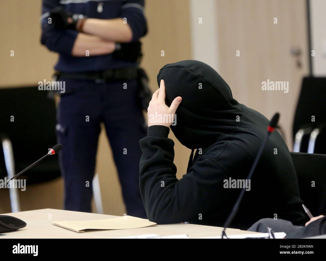 Essen, Germany. 05th Mar, 2020. The accused (r) waits in the dock for the beginning of the trial. The accused is accused of having locked up his two-year-old son in a very hot place and left him to his fate. A day later, the boy was dead. Credit: Roland Weihrauch/dpa/Alamy Live News Stock Photo