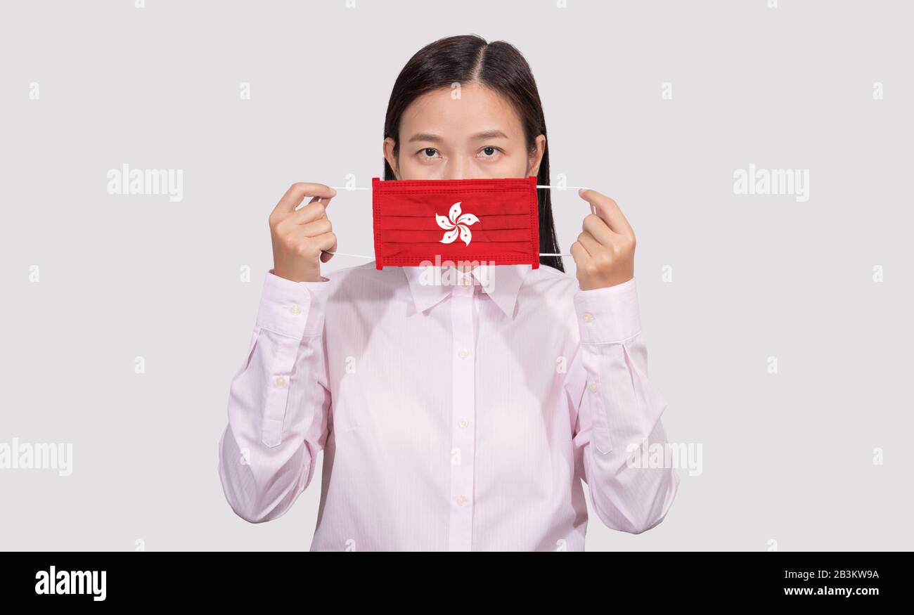 Asian woman wearing hygienic face mask painting Hong Kong flag to protect from the Coronavirus 2019 (COVID-19) infection outbreak situation, the virus Stock Photo