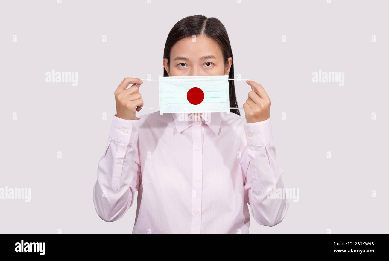 Asian woman wearing hygienic face mask painting Japan flag to protect from the Coronavirus 2019 (COVID-19) infection outbreak situation, the virus ori Stock Photo