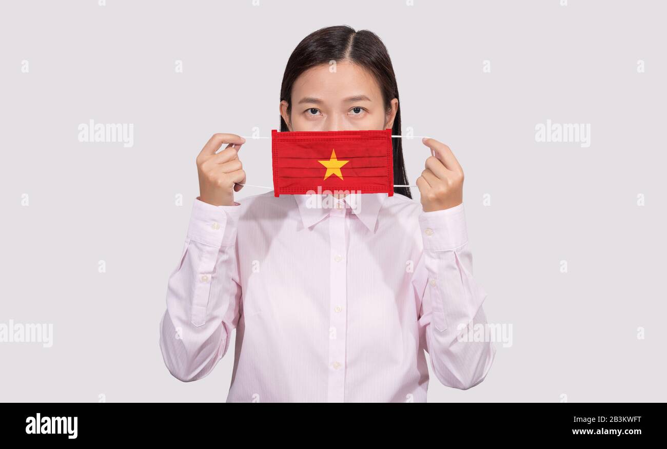 Asian woman wearing hygienic face mask painting Vietnam flag to protect from the Coronavirus 2019 (COVID-19) infection outbreak situation, the virus o Stock Photo