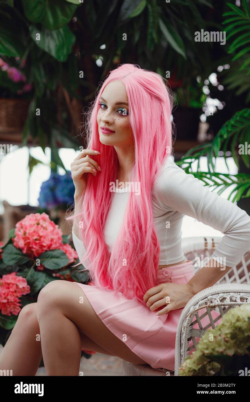 Beautiful young woman posing in the winter garden. Girl in a pink wig and  in sexy clothes. Cosplay idea and concept garden greenhouse background.  Fash Stock Photo - Alamy