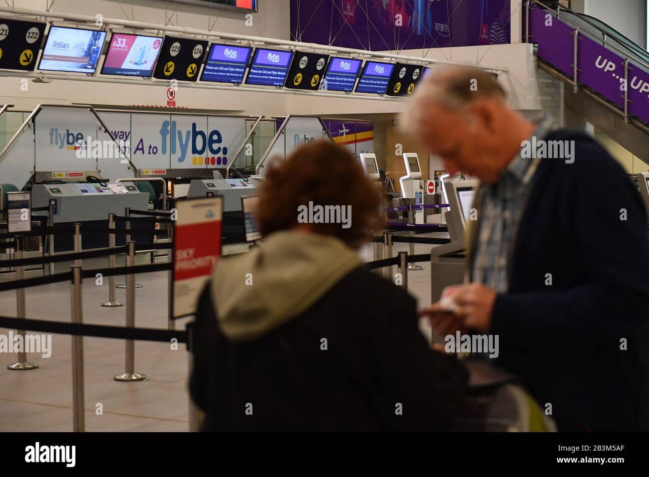 Passengers stand by empty checkin desks at Birmingham International