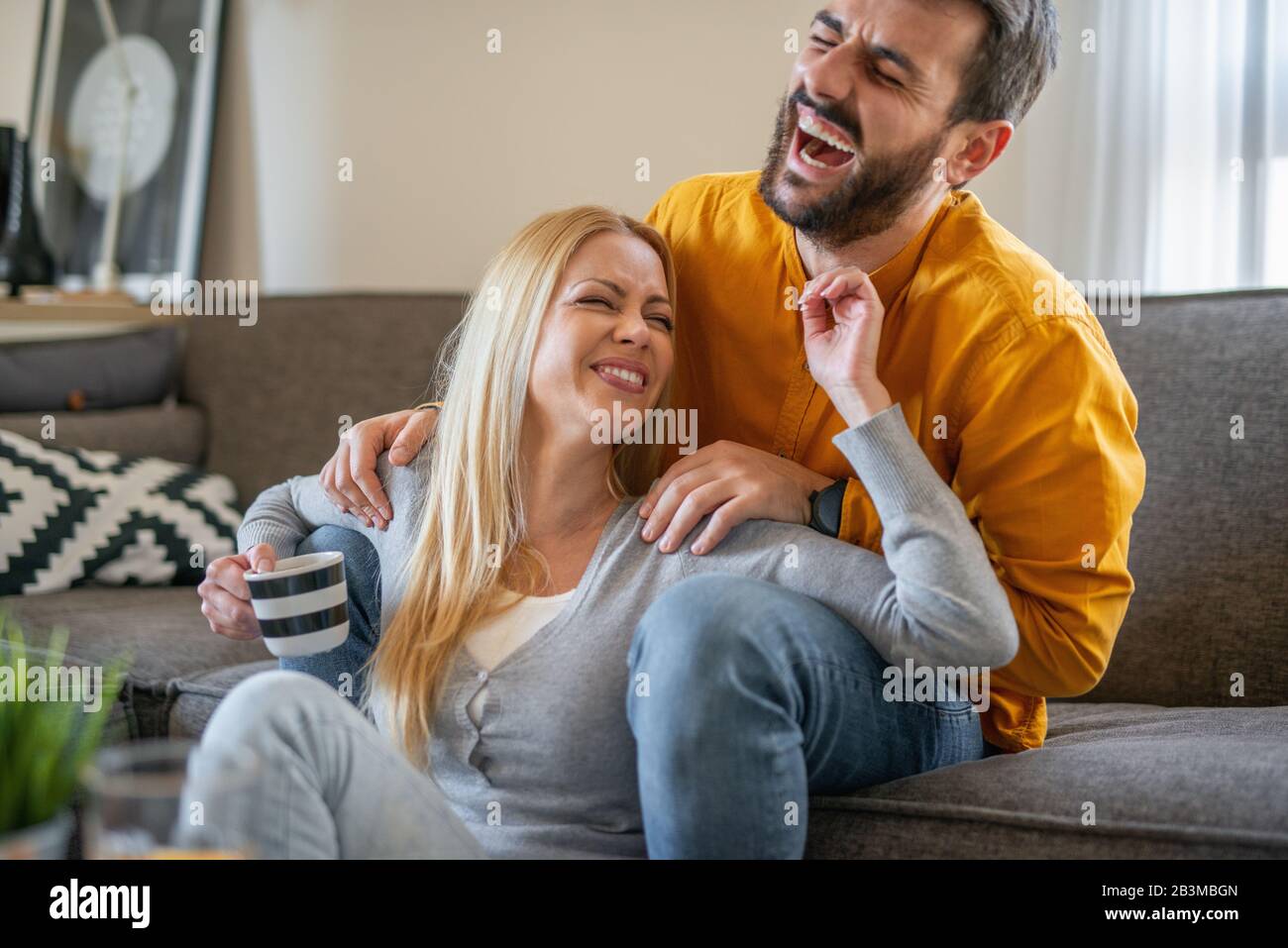 Young couple relaxing at home with cup of coffee.Spending nice time together.Young couple in the morning at home. Stock Photo