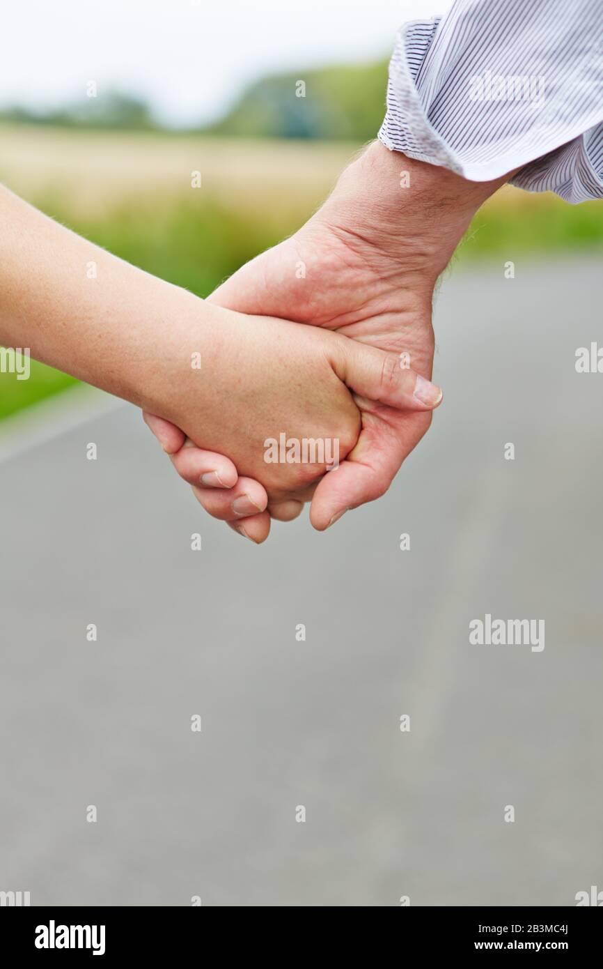 Couple of seniors holding hands while walking Stock Photo - Alamy