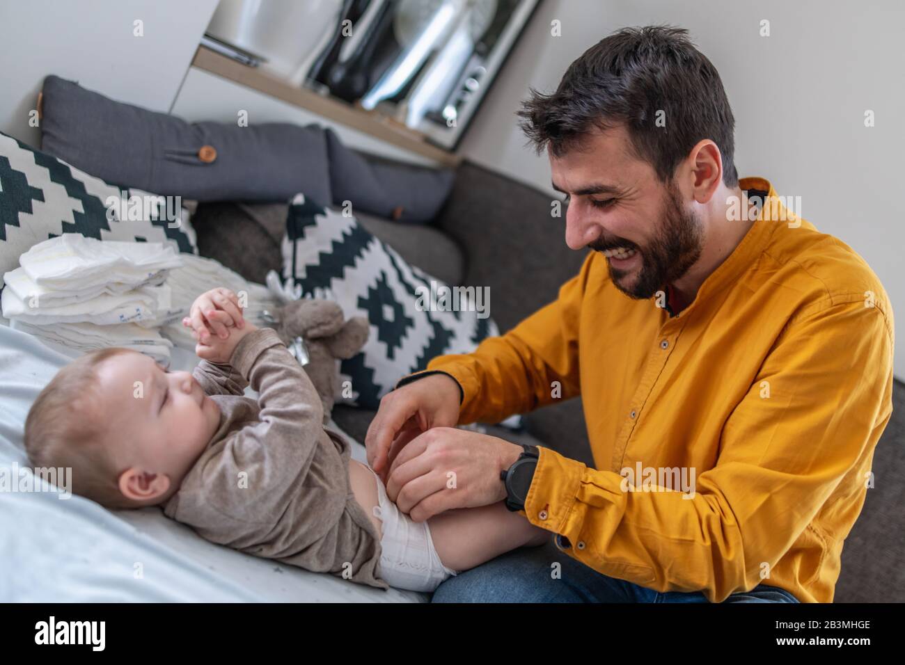 Father and baby.Young dad is changing baby diaper.Happiness and harmony