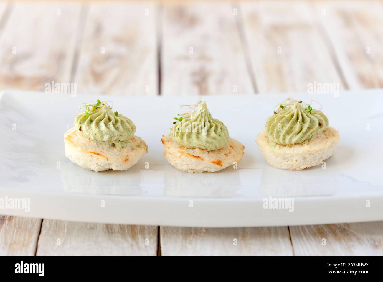 Mini cauliflower casseroles with avocado cream on a white plate Stock Photo