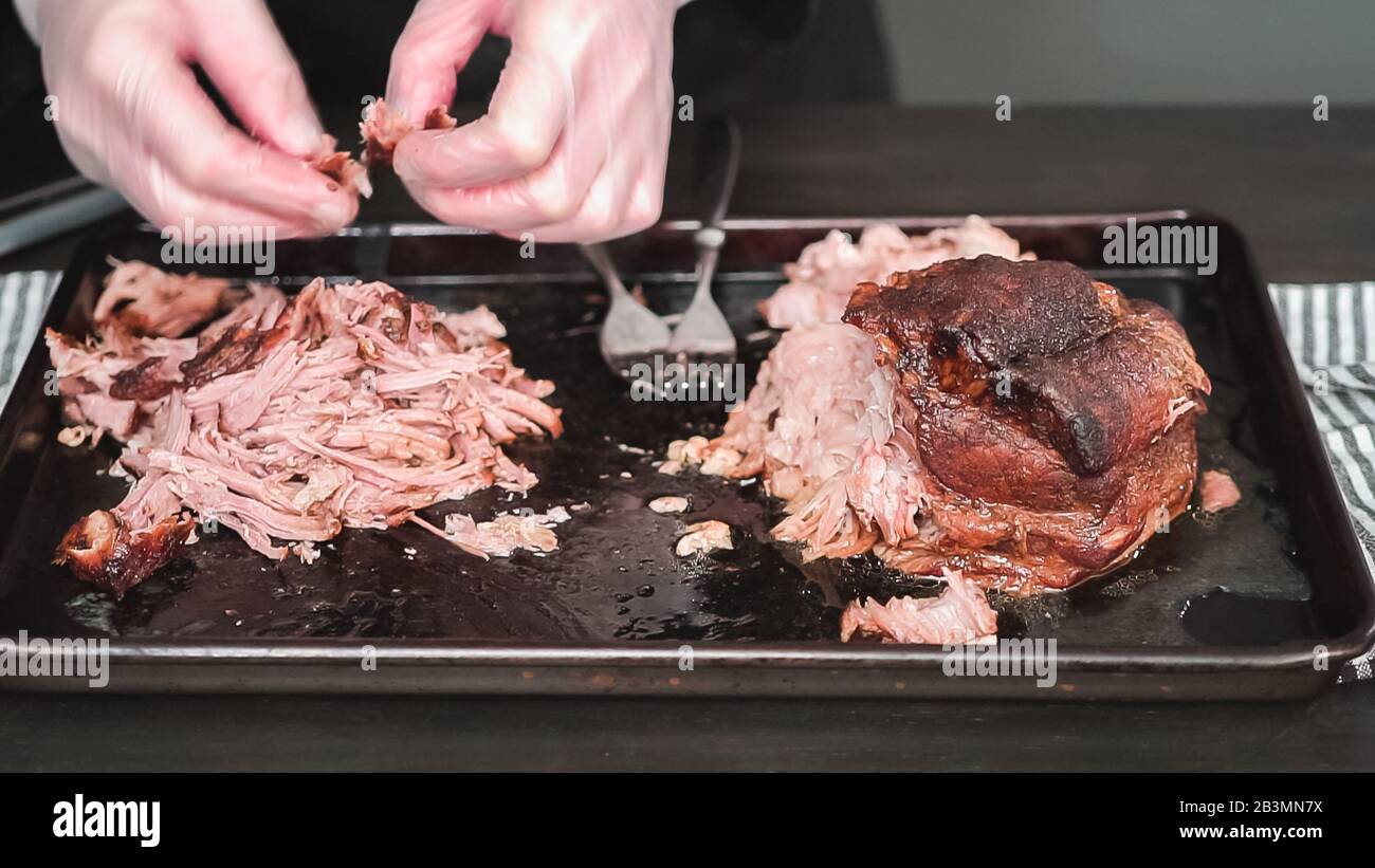 Step by step. Shredding pork roast shoulder with two forks Stock Photo