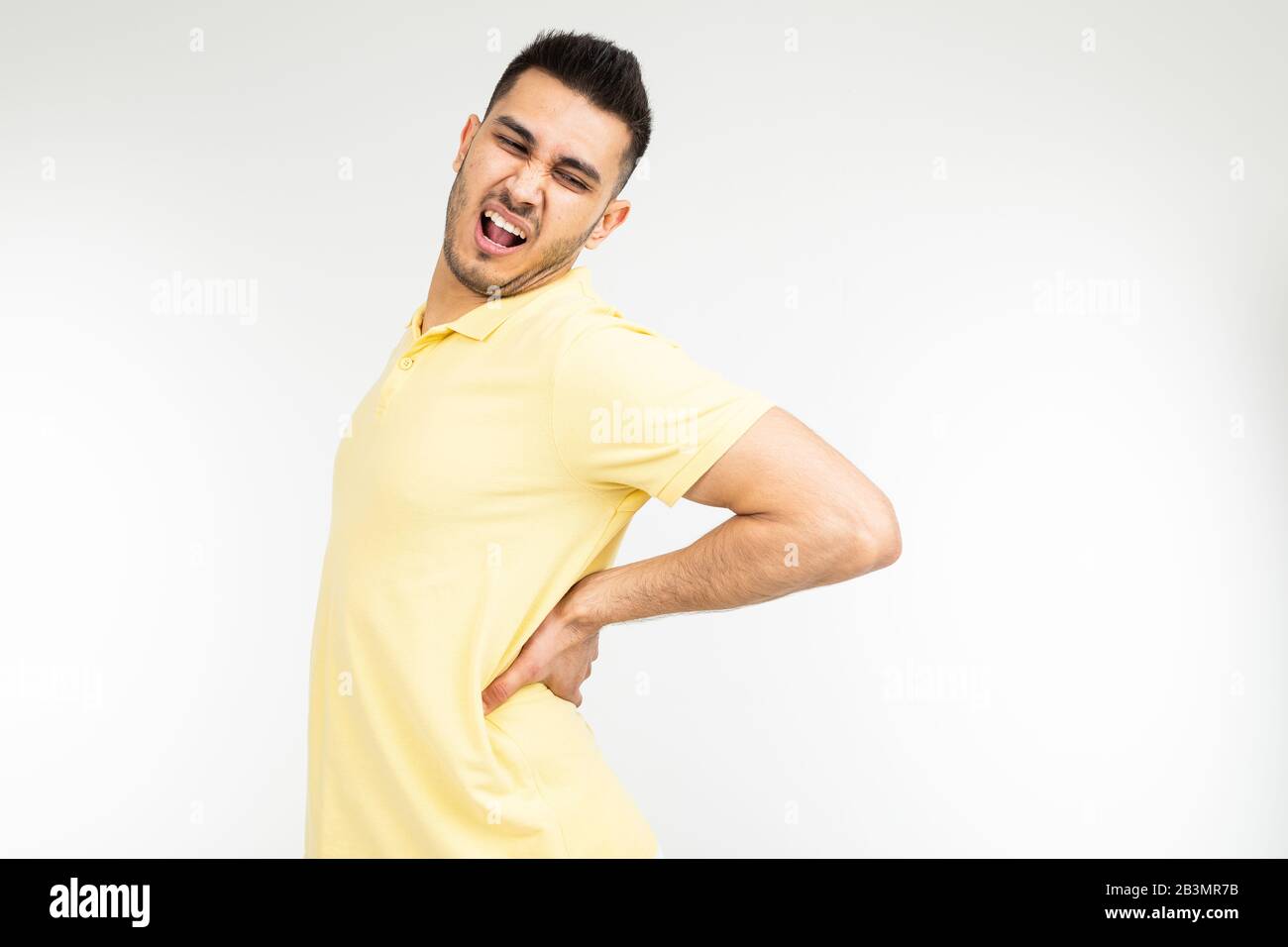 young man pulled back muscle on a white studio background with copy