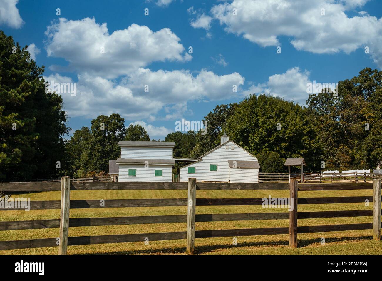 Old Barns with Green Shutters Past Fence Stock Photo