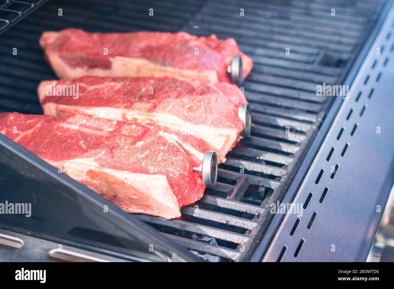 Grilling New York strip steak on outdoor gas grill Stock Photo Alamy