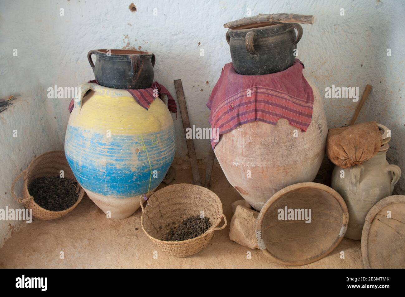 Such domestic implements are traditional for underground living  - Tunisia, North Africa. There are wood plate, fictile craft jars, maunds on the phot Stock Photo