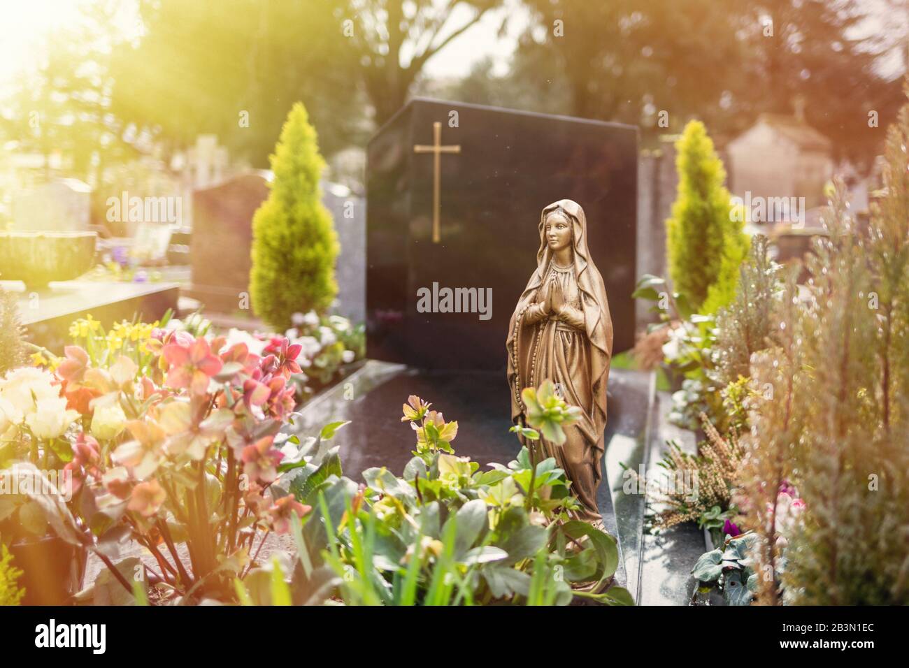Virgin Mary at cemetery, graveyard background, tombstone, sunlight tone