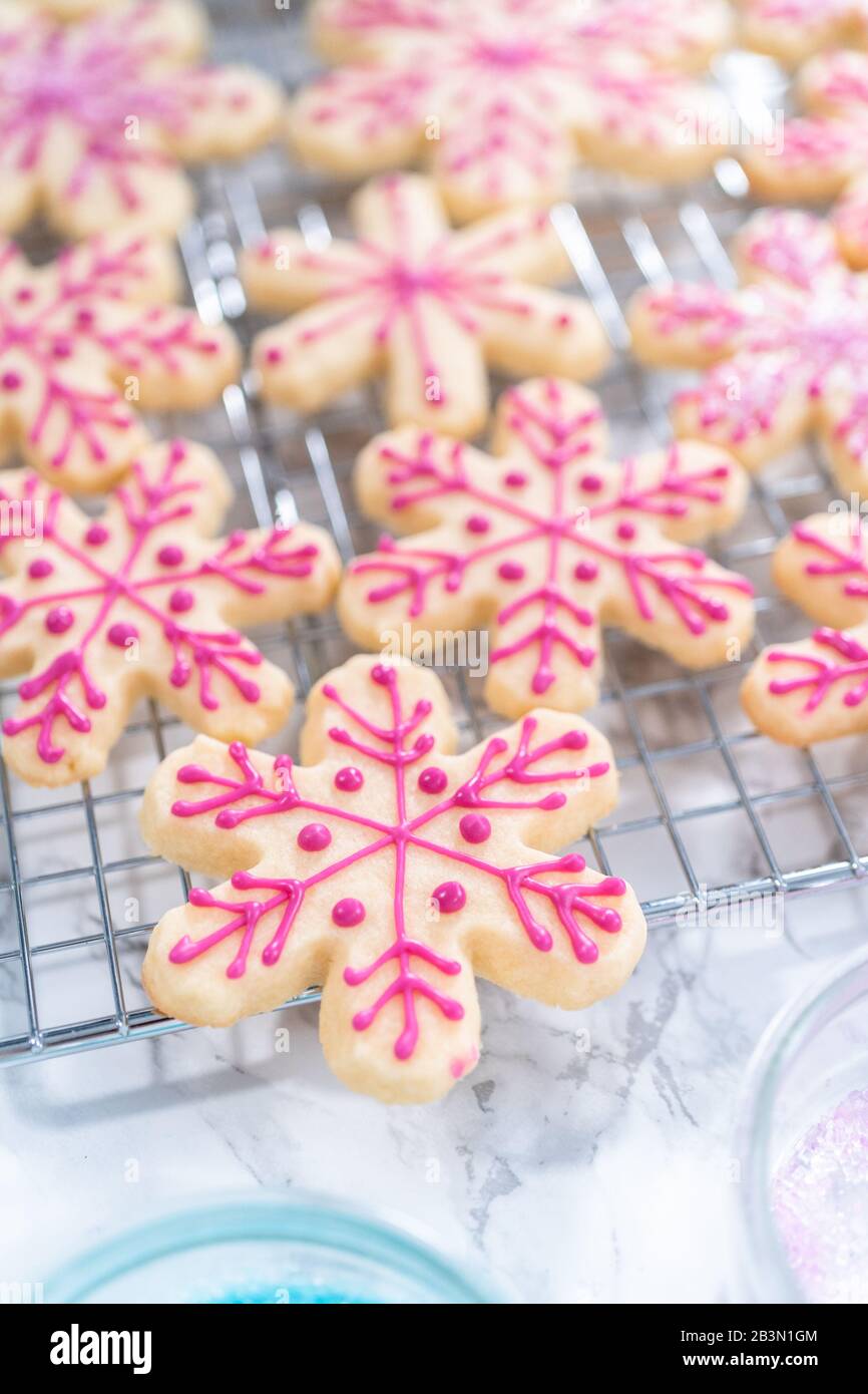 Decorating Christmas sugar cookies with royal icing and sprinkles Stock