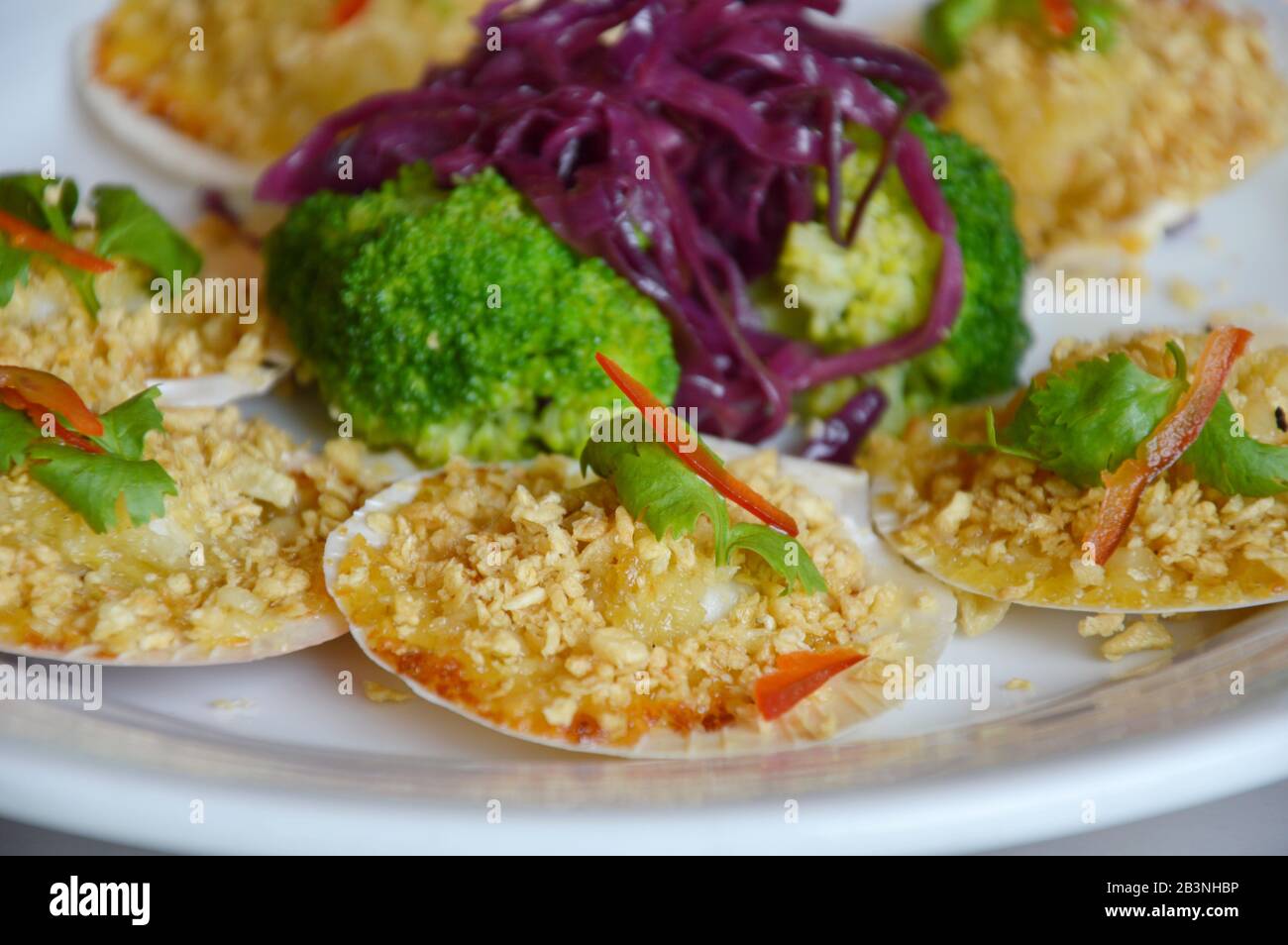 baked scallops with cheese topping fried garlic and boiled vegetable on