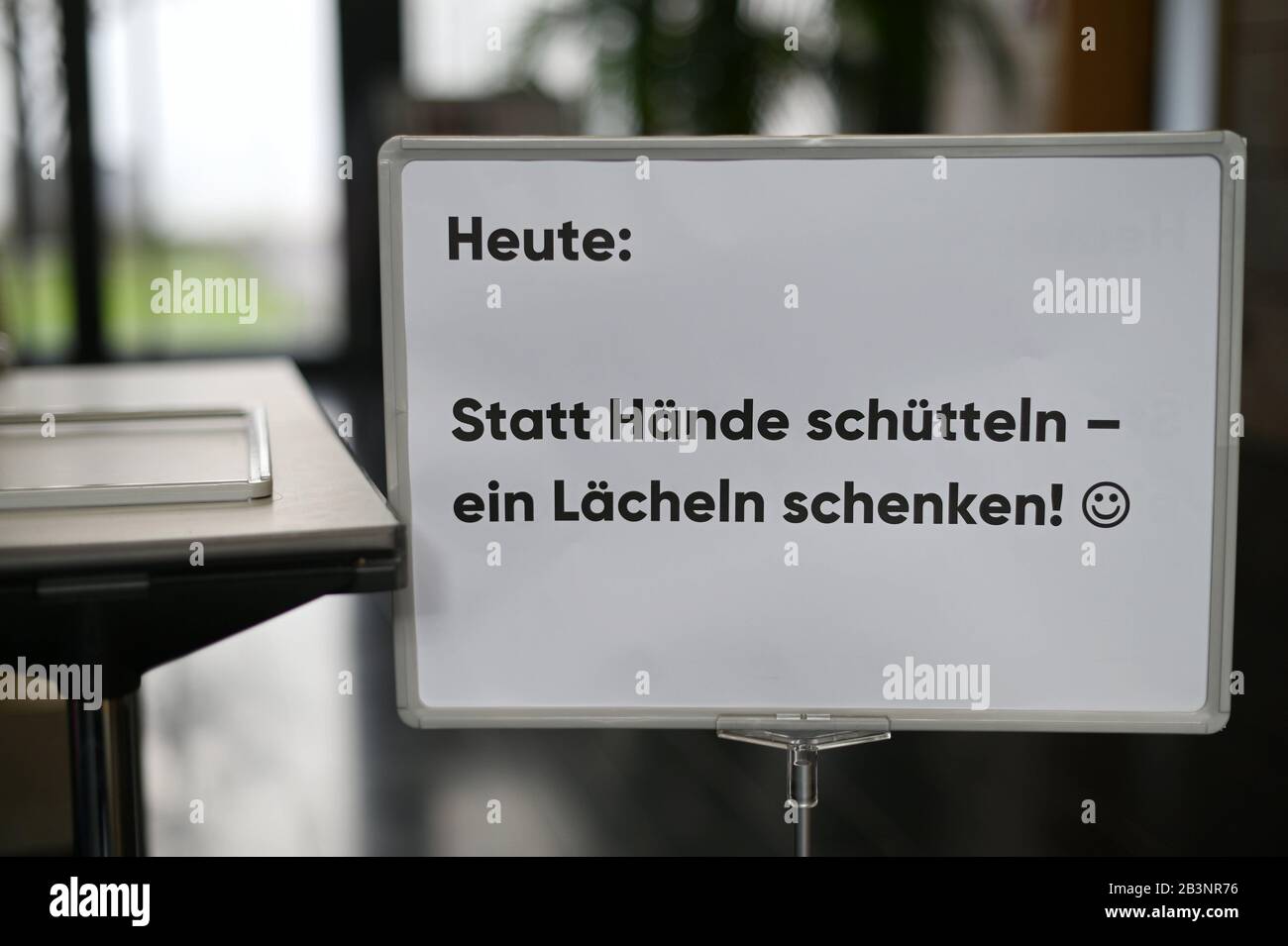 Berlin, Germany. 05th Mar, 2020. A sign with the inscription 'Heute statt Hände schütteln - ein Lächeln schenken' (Today instead of shaking hands - give a smile) is located in the entrance area for the event Medientage Mitteldeutschland. This is intended as a precautionary measure because of the corona virus currently in circulation. The event will precede the main Leipzig congress in May. Credit: Frank May/dpa - Zentralbild/dpa/Alamy Live News Stock Photo