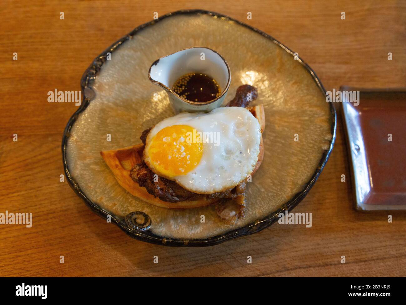 Duck and Waffle restaurant - the signature dish of Crispy Duck with fried egg and waffle on a plate, Duck & Waffle, Bishopsgate East London London UK Stock Photo