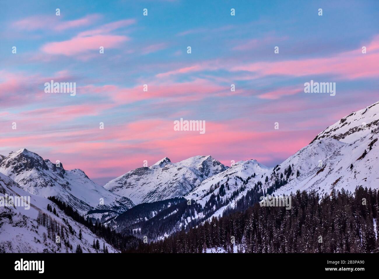 Pink clouds lie in a blue sky above a snowy alpine panorama Stock Photo ...