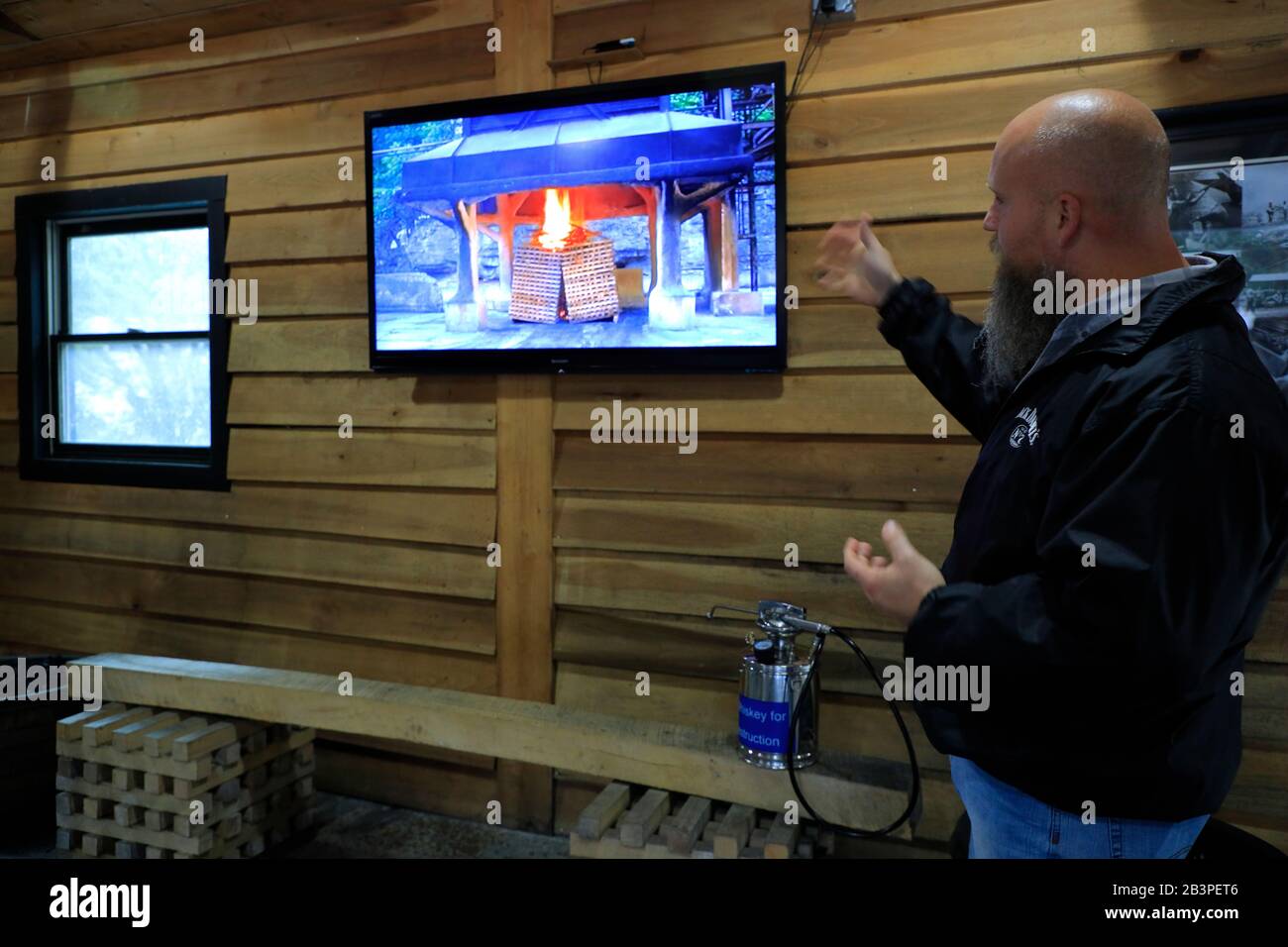 Tour guide showing the video of making charcoal from sugar maple