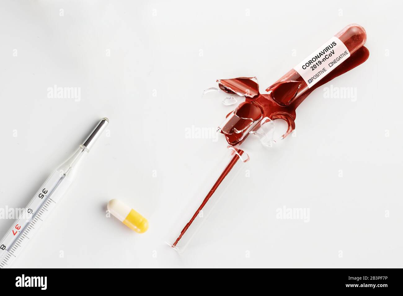 Broken borosilicate glass tube with Coronavirus infected blood, thermometer and pill on white. Coronavirus, COVID-19, pandemic and medicine concepts Stock Photo