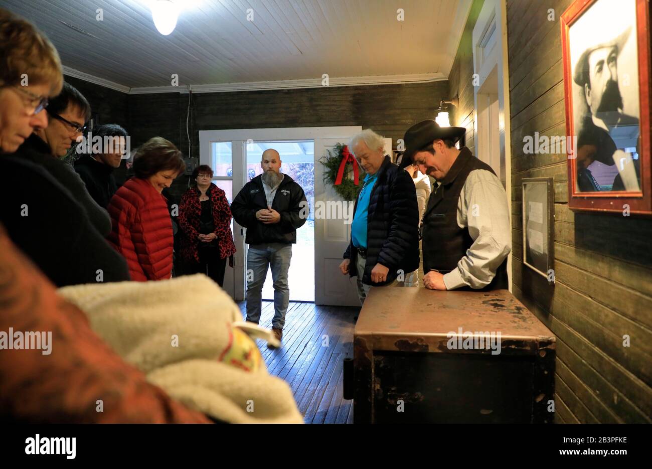 Tour guide with visitors looking at the original safe inside the Jack