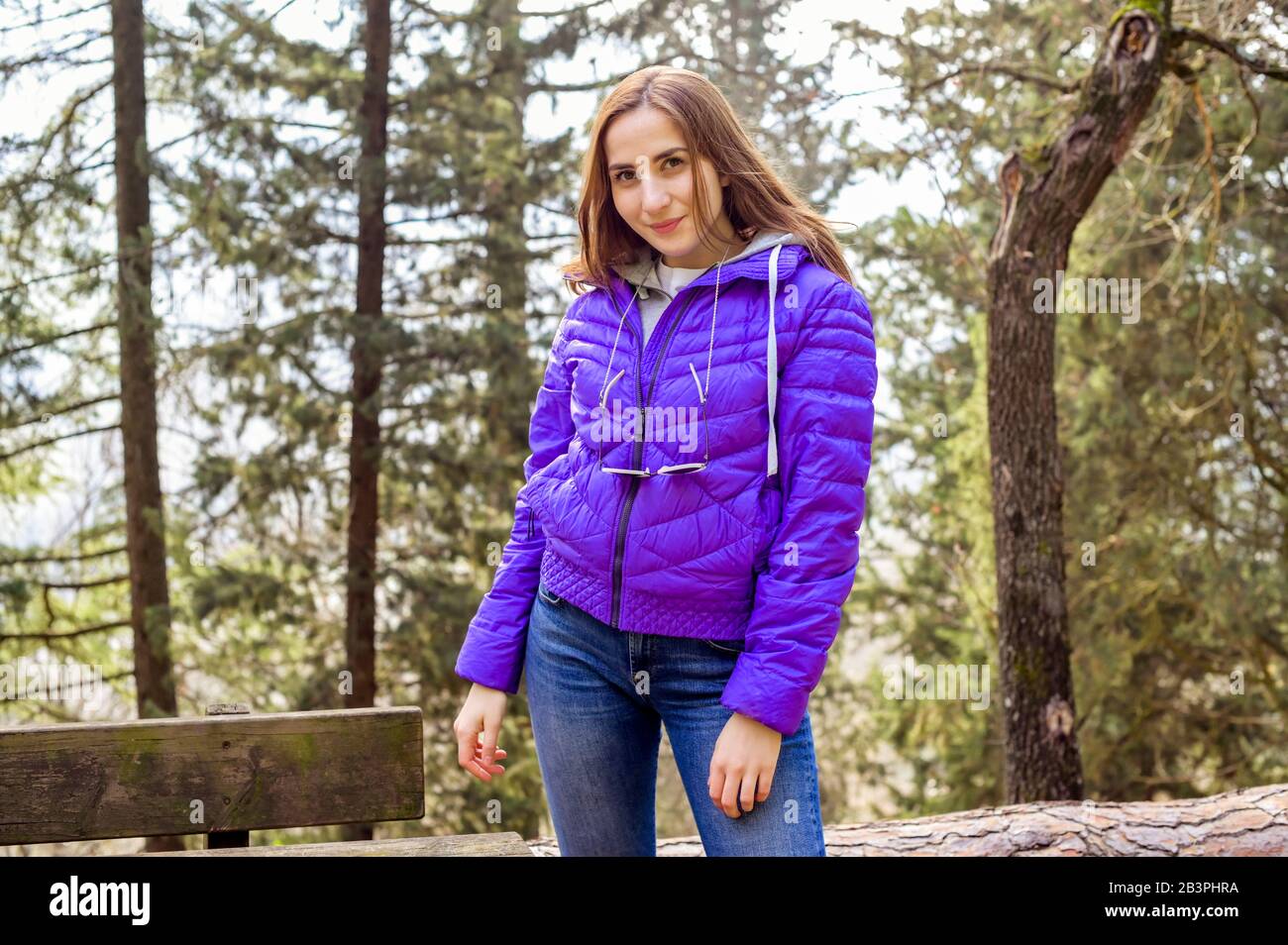 Young Girl in a purple jacket in a spring park. Sunlight