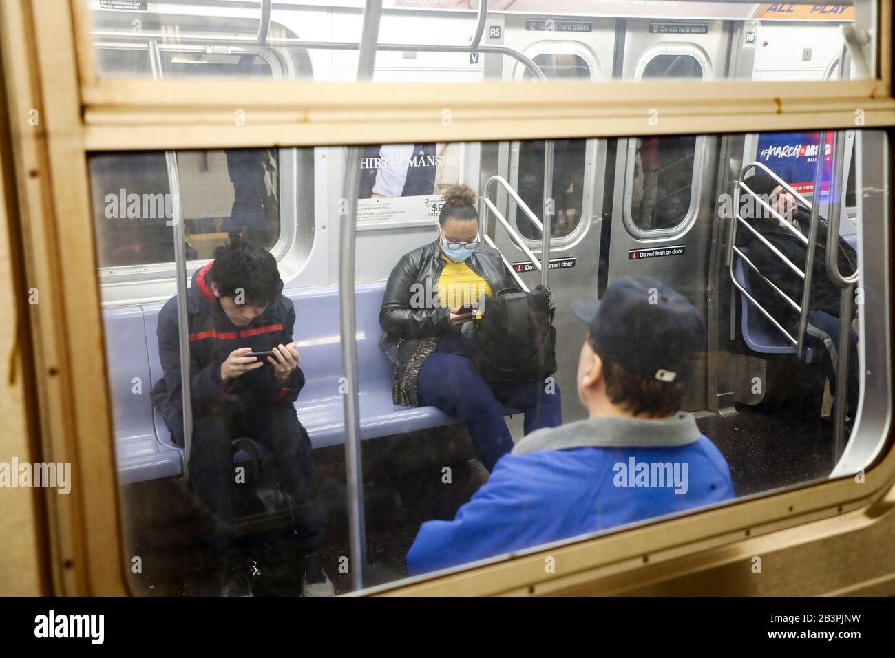 New York, USA. 4th Mar, 2020. A passenger with face mask is seen in a metro train in Manhattan of New York, the United States, March 4, 2020. U.S. health authorities on Wednesday reported a total of 129 confirmed cases of COVID-19 and a death toll of 11 in the country. Credit: Wang Ying/Xinhua/Alamy Live News Stock Photo