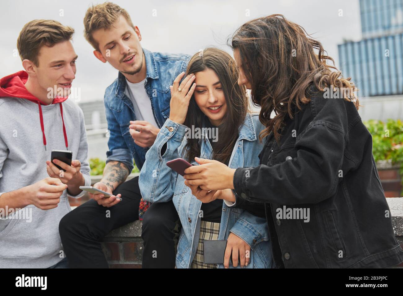 Group of friends using their mobile phone in the city Stock Photo