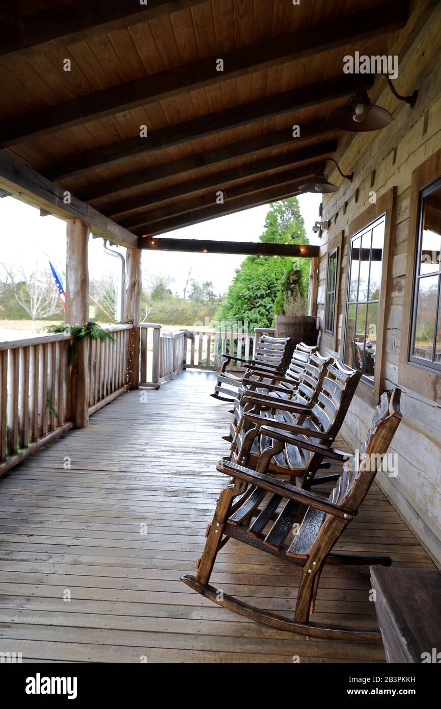 Rocking chairs on the porch of the historic log home contain gift shop and tasting room of Leiper's Fork Distillery.Franklin.Tennessee.USA Stock Photo