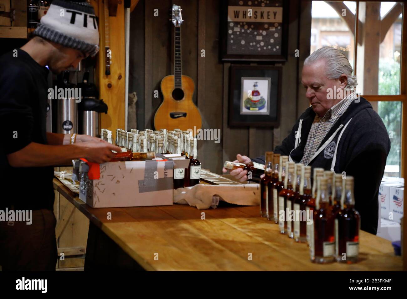 Workers hand labeling whiskey bottle inside Leiper's Fork Distillery.Franklin.Tennessee.USA Stock Photo