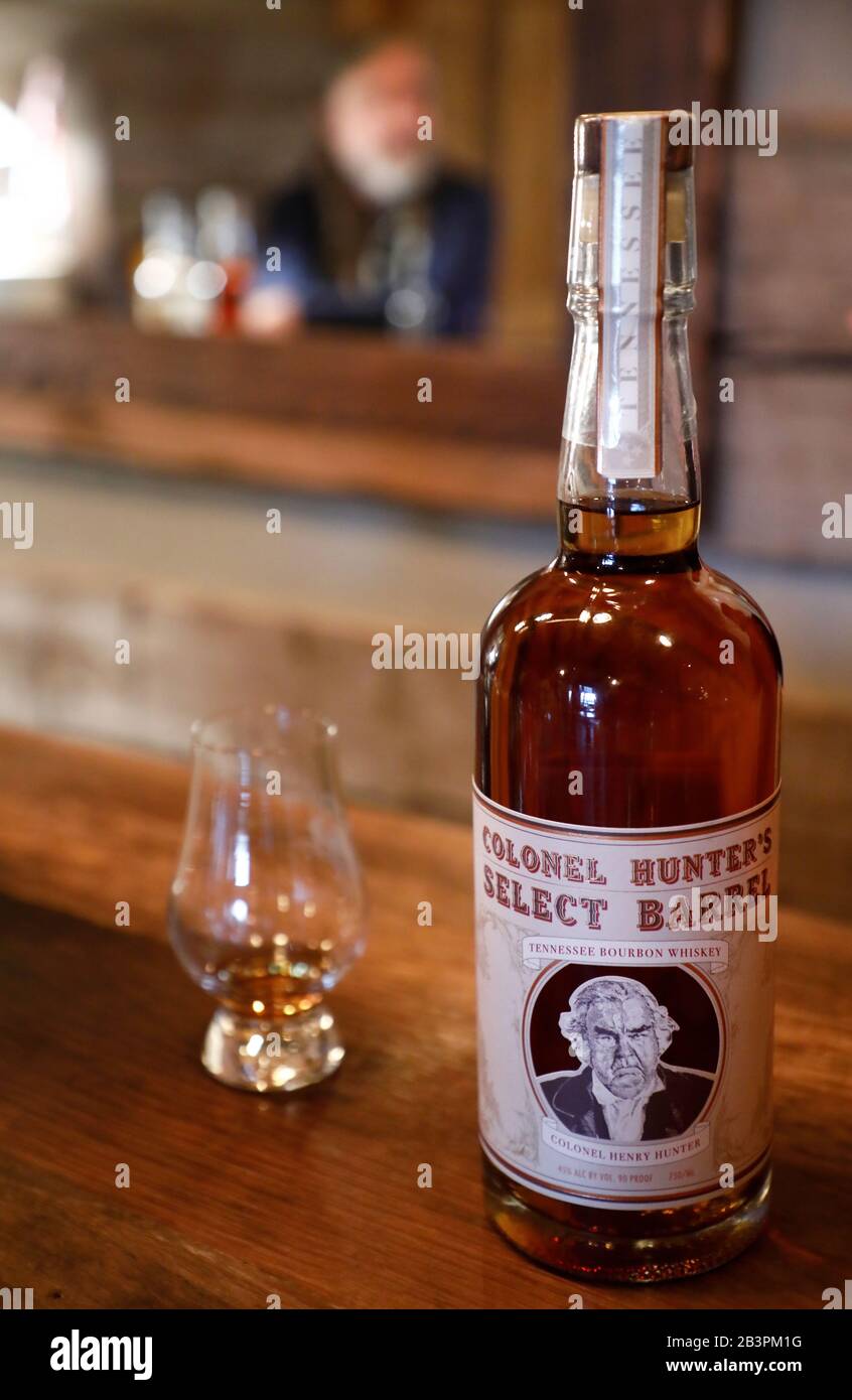 A bottle of Colonel Hunter's Select Barrel whiskey with a tasting glass on the table of tasting room in Leiper's Fork Distillery.Franklin.Tennessee.USA Stock Photo