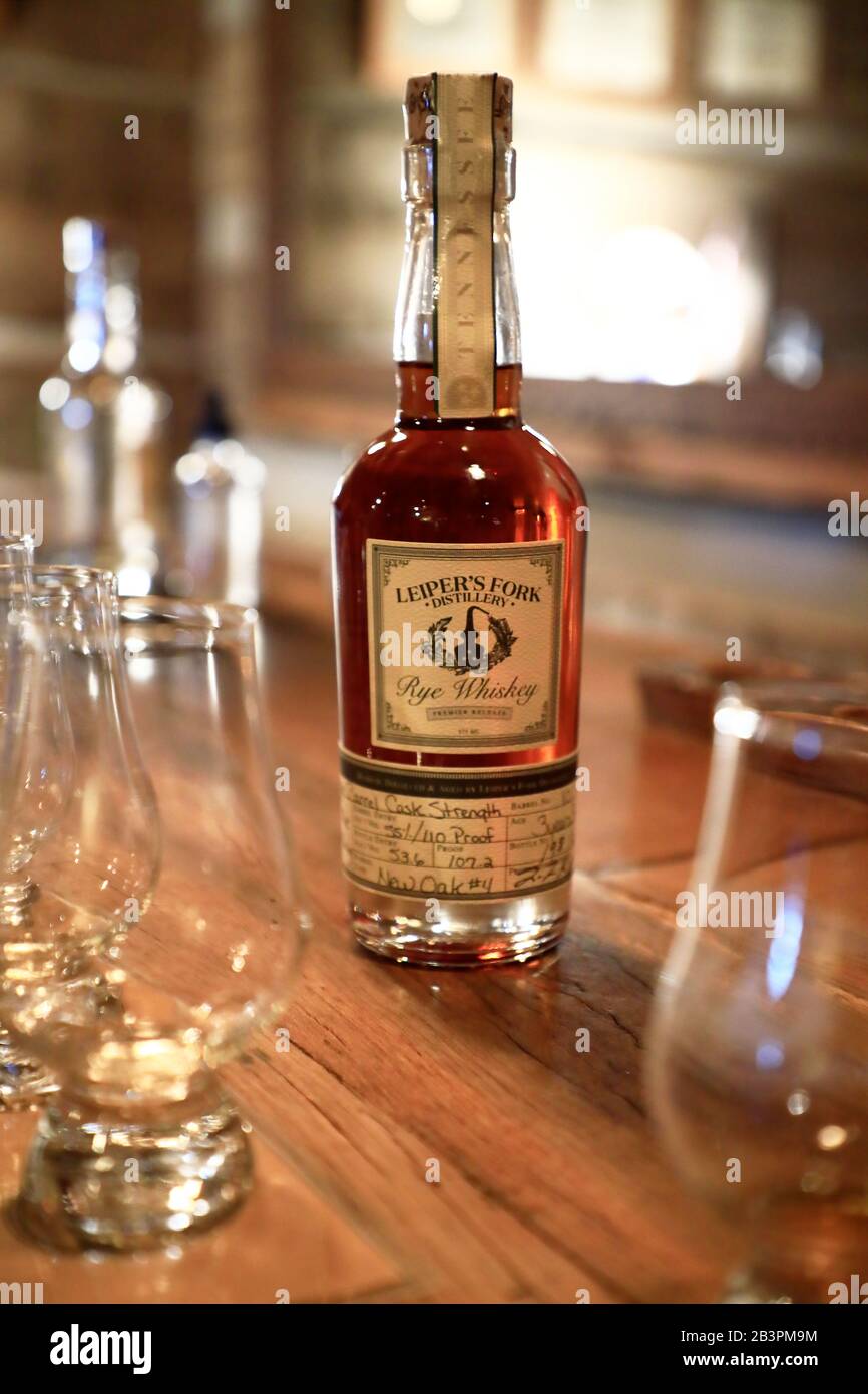 A bottle of rye whiskey from Leiper's Fork Distillery on the table top with tasting glasses in tasting room.Leiper's Fork Distillery.Franklin.Tennessee.USA Stock Photo